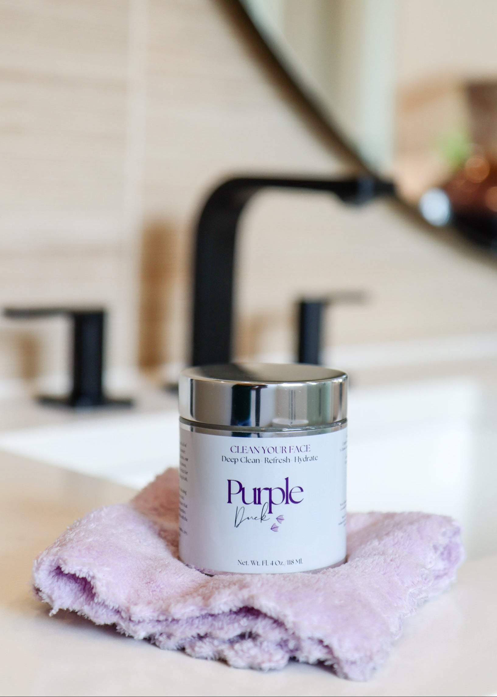 Facial cleanser sitting on bathroom counter with purple rag