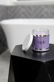 Purple duck bath salts sitting next to a bath tub