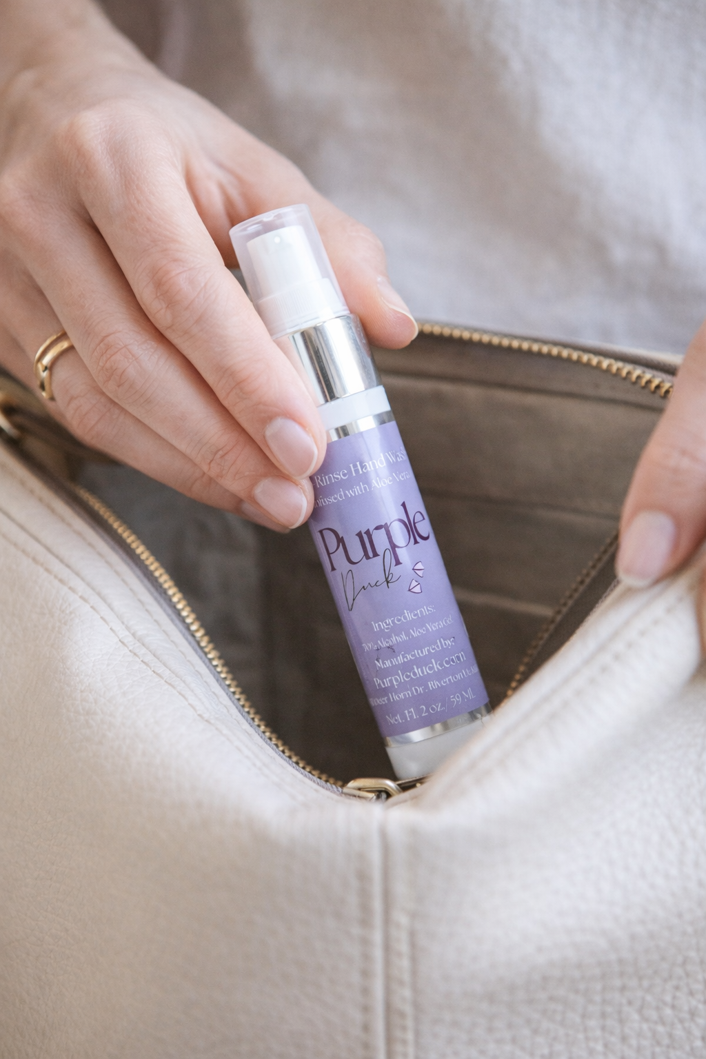 Person pulling Purple Duck Hand Sanitizer out of their bag to spray on their hands 