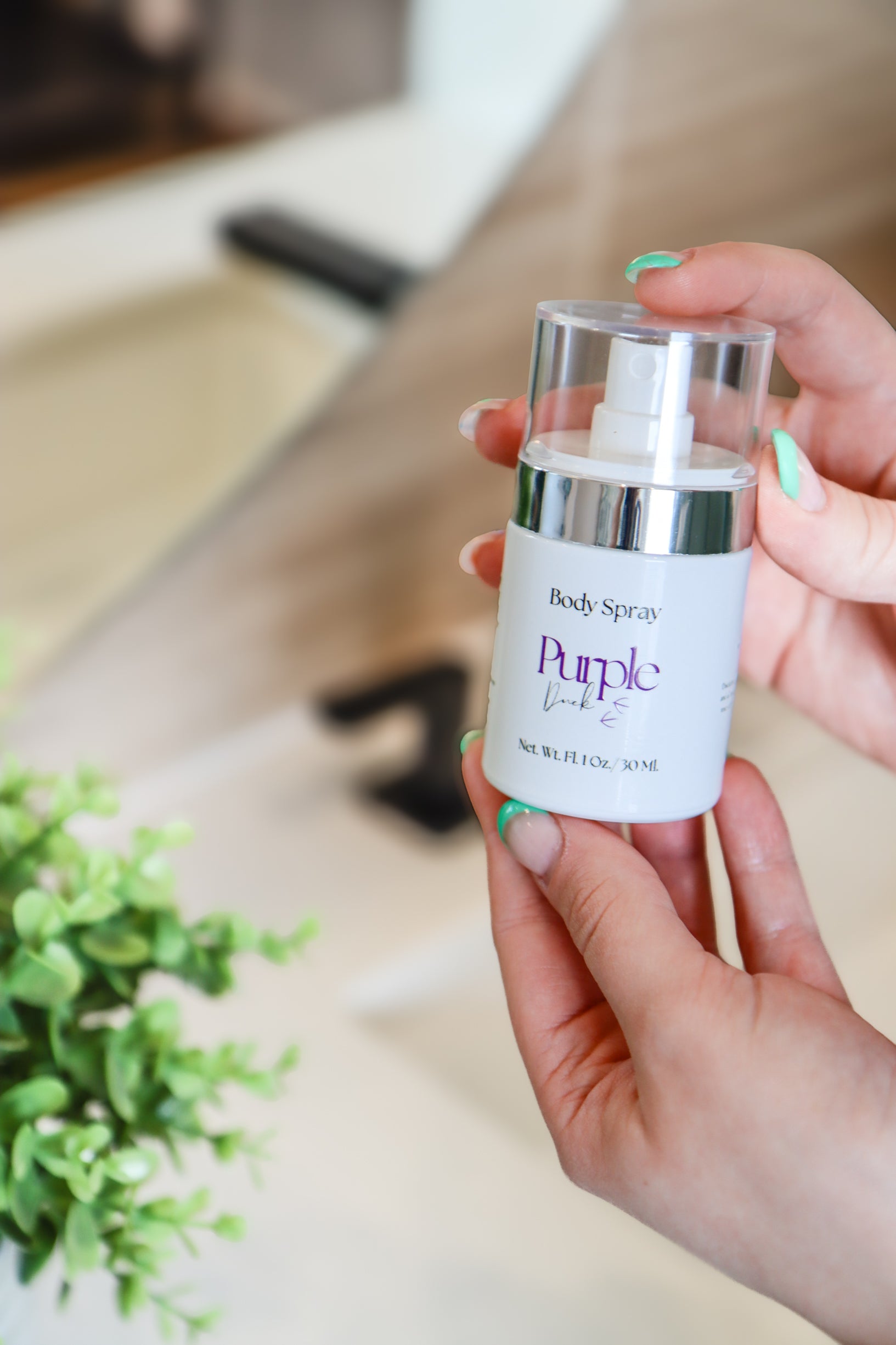 1 oz Purple Duck natural perfume being held in a bathroom