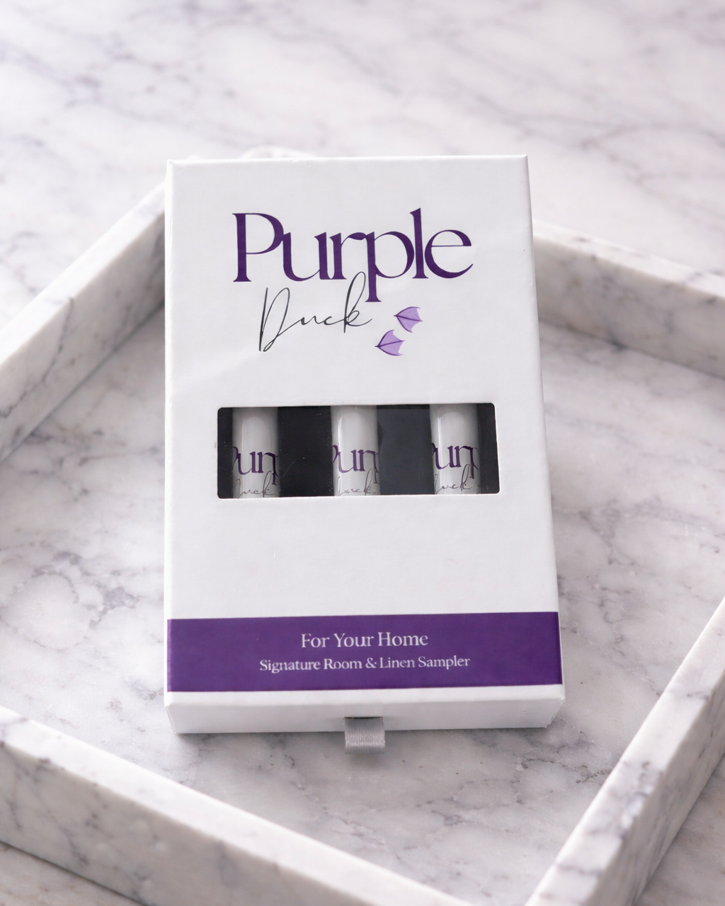 Purple Duck Room Spray Discovery Set sitting on a table 