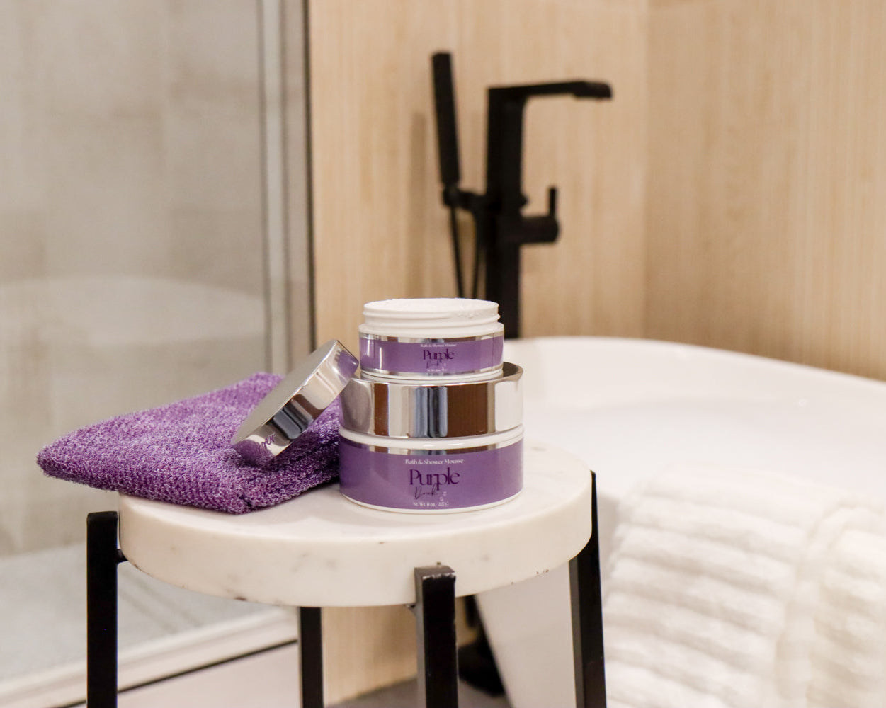 Purple Duck Foaming Shower Mousse sitting next to purple rag